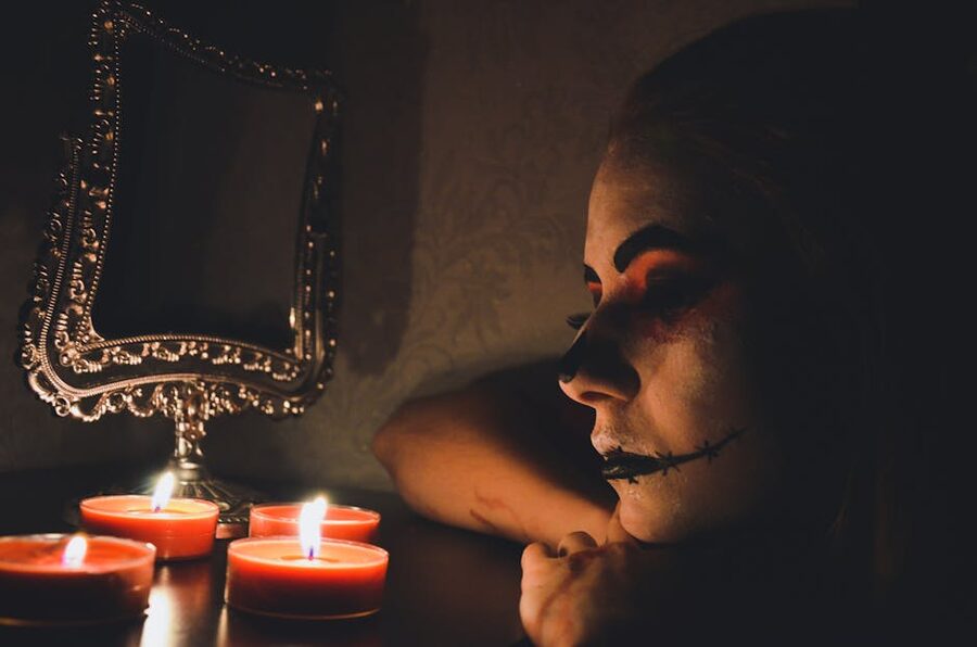 Eerie costumed actor with candles in dark London Dungeon scene