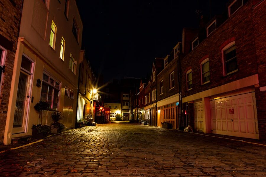 London cobblestone alley with warm street lighting at night