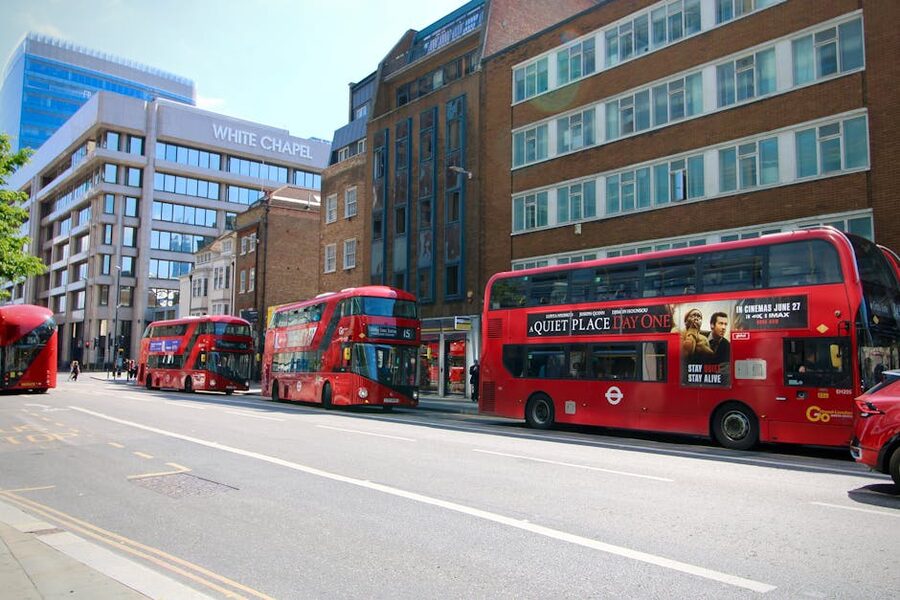 Modern Whitechapel London street with red double-decker buses