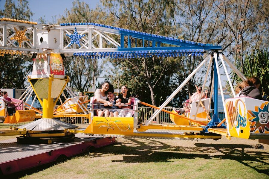 Families enjoying amusement park ride sunny day