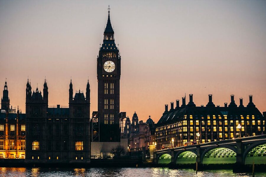 Big Ben and Westminster lit gold at night seen from Westminster Bridge