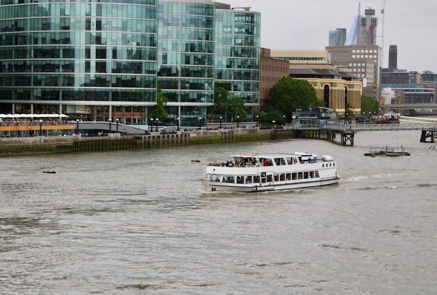Sightseeing boat on River Thames with London city skyline