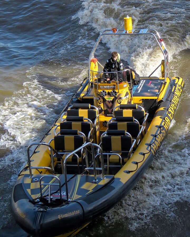 RIB speedboat under Tower Bridge open span Thames