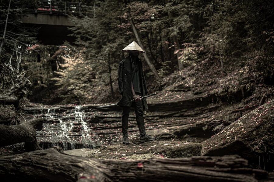 Lone samurai with sword in atmospheric forest setting
