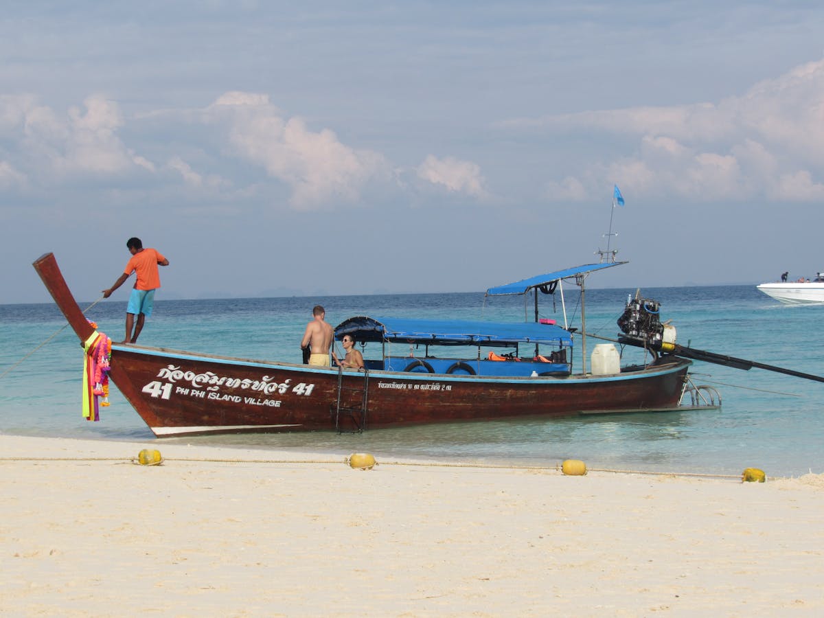 Colorful longtail boat on sandy beach at Phi Phi Island under clear sky