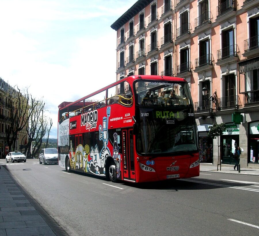 Open-top double-decker sightseeing bus on the streets of Madrid