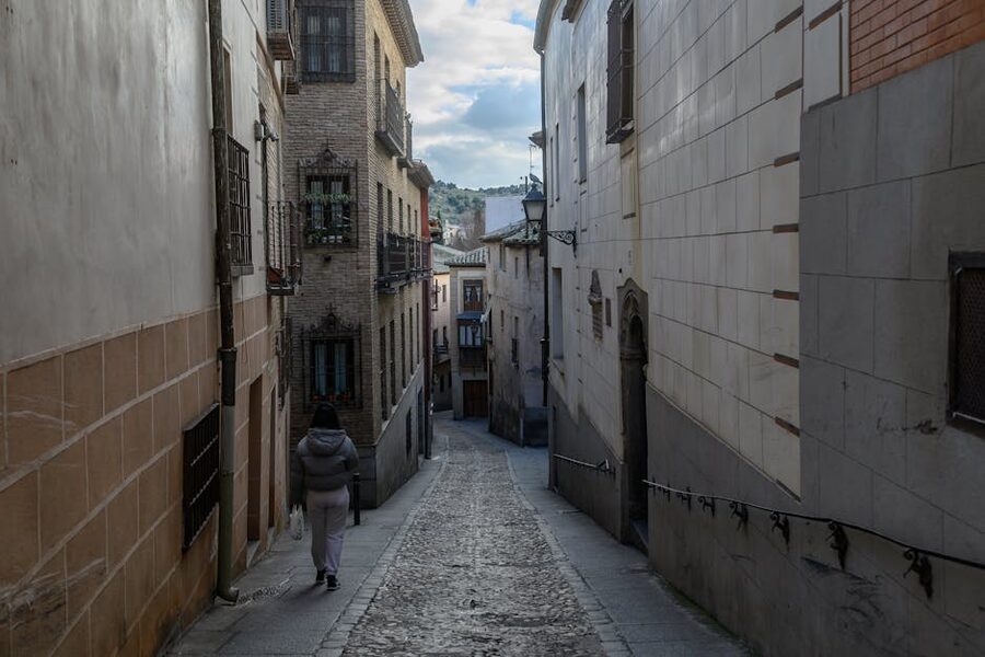 Narrow cobblestone street in Toledo old town with historic stone buildings
