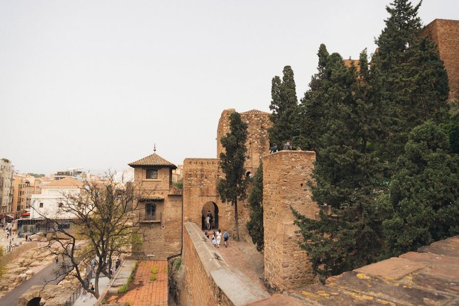Alcazaba of Malaga fortress walls with greenery on the hillside
