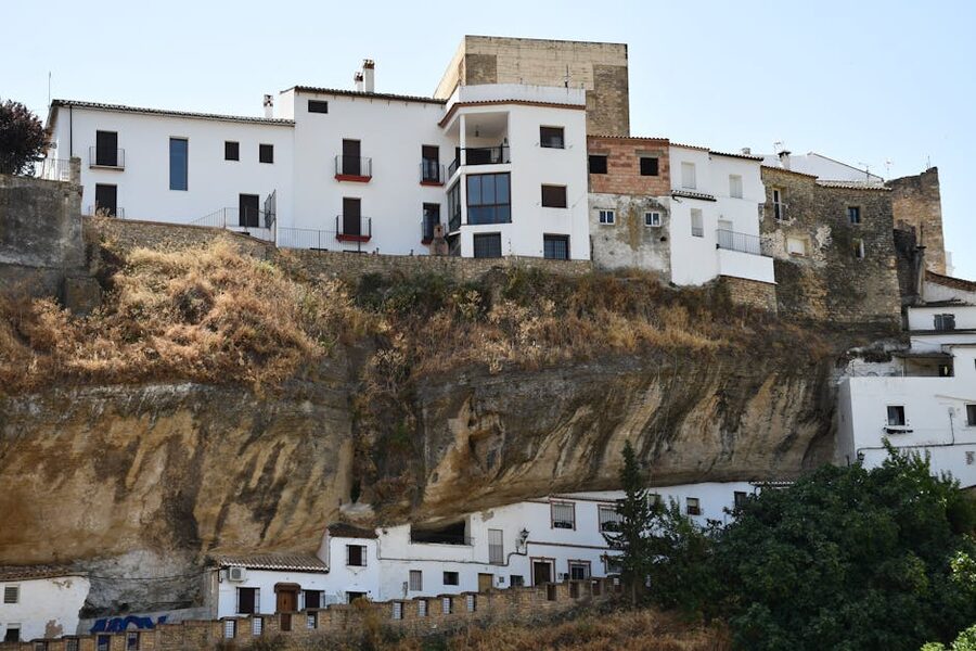 Cliffside white houses in Setenil de las Bodegas Spain tucked under rock overhangs