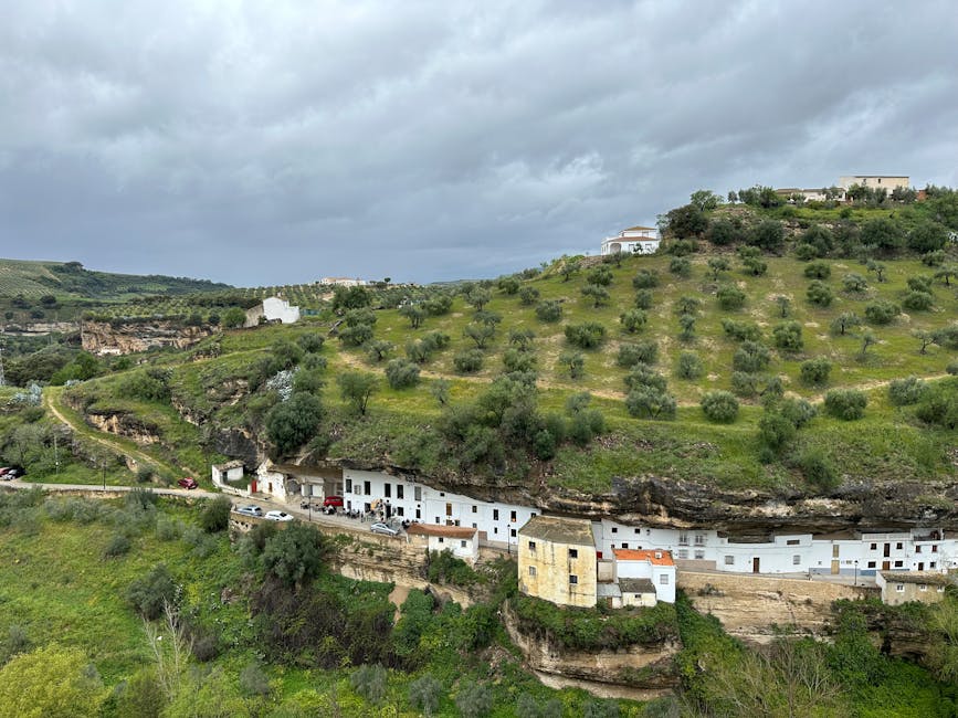 Green view of Setenil de las Bodegas with cliffside houses and surrounding fields