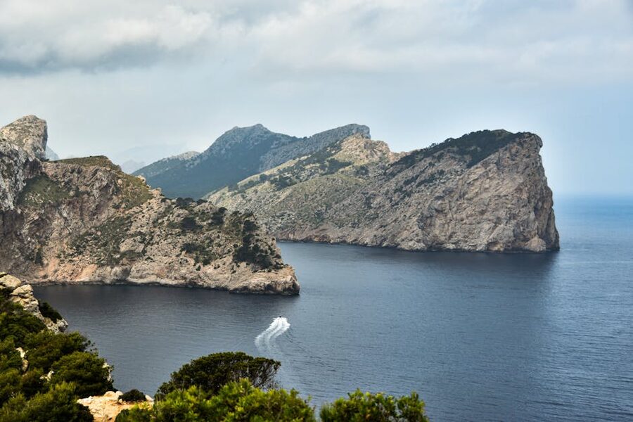 Cliffs and ocean with a passing speedboat off Mallorca's Tramuntana coast