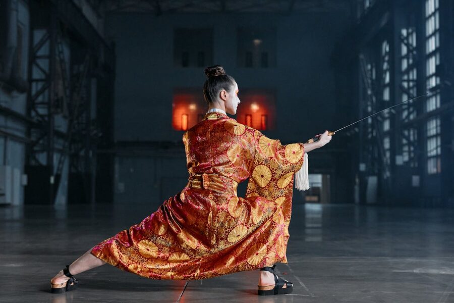 Person in elaborately patterned kimono performing sword kata movements