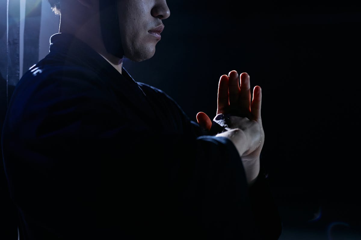 Martial artist in traditional attire in a studio embodying focus and discipline