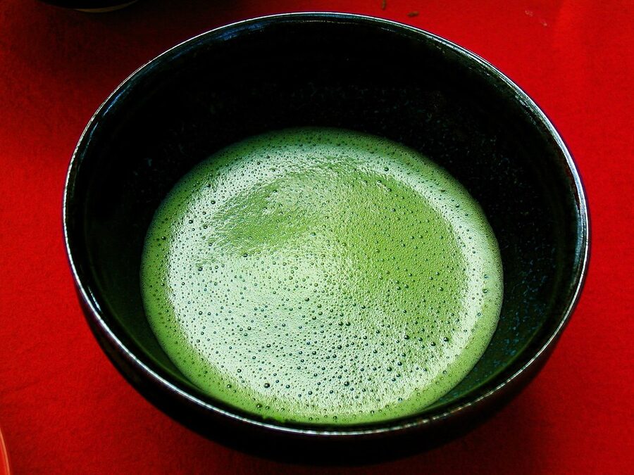 Matcha being whisked in a tea bowl with chasen