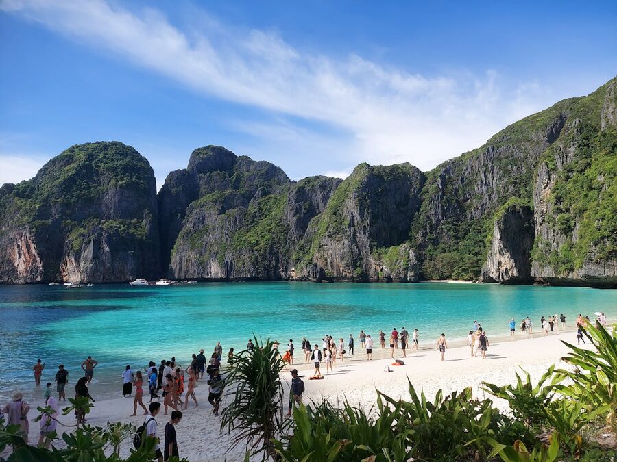 Crowded beach at Maya Bay with limestone cliffs and turquoise water