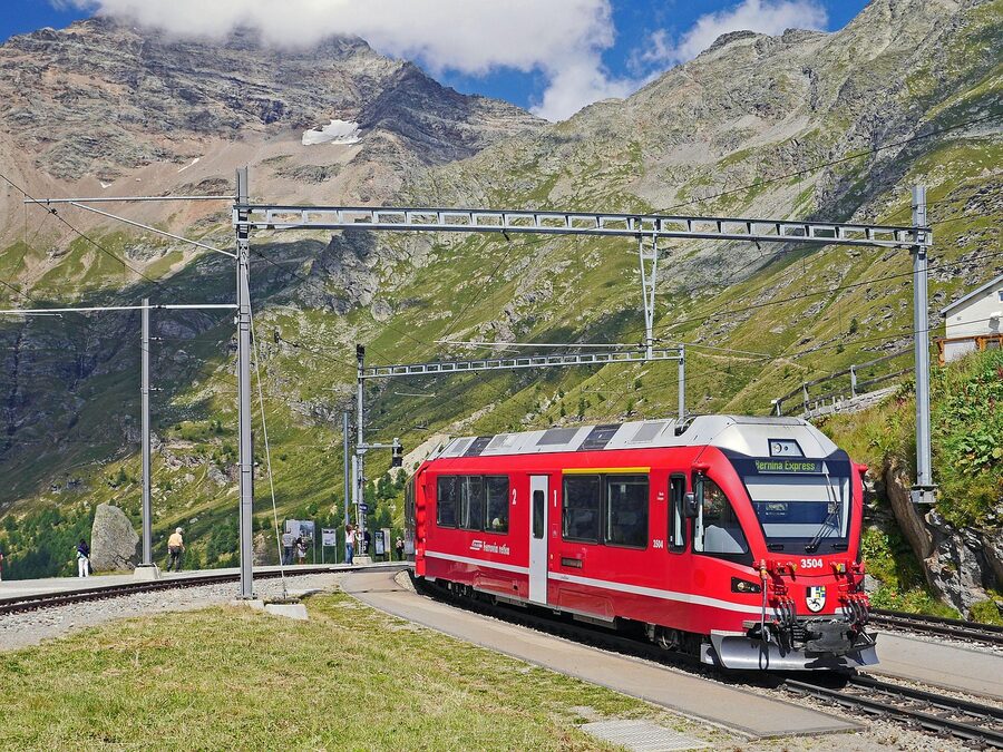 Bernina Express at Alp Grüm station with Piz Palü glacier view