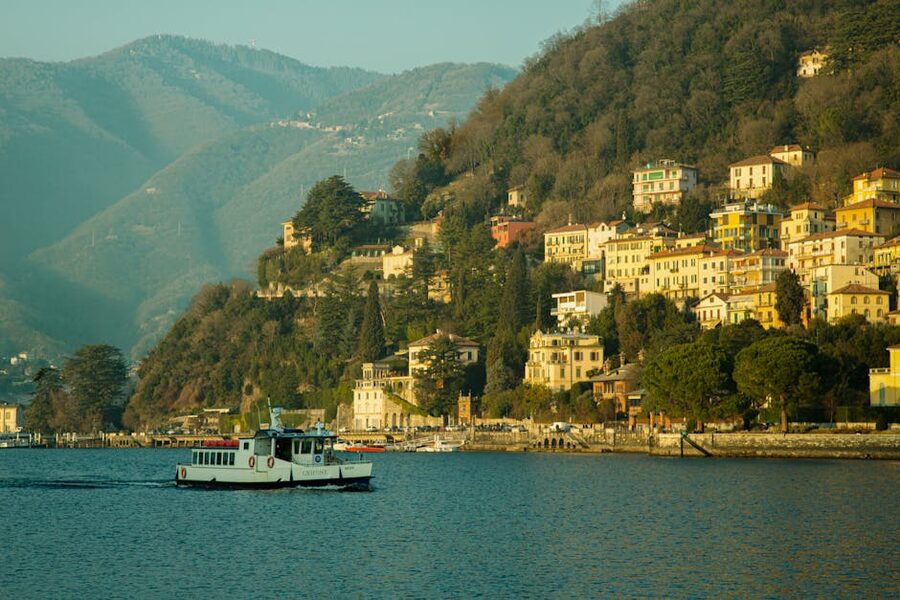 Public ferry passing colourful hillside houses on a Lake Como day trip from Milan