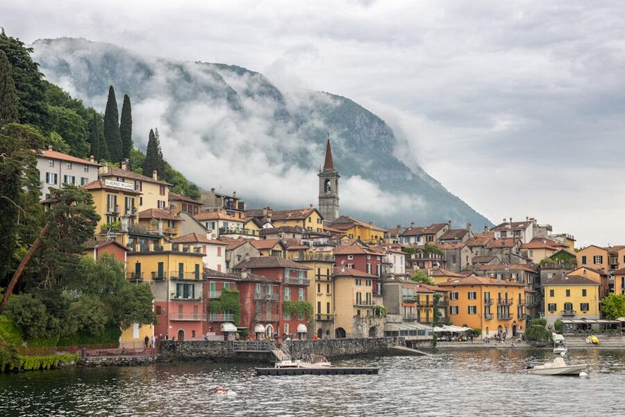 Varenna with colorful buildings and misty mountains by Lake Como at morning
