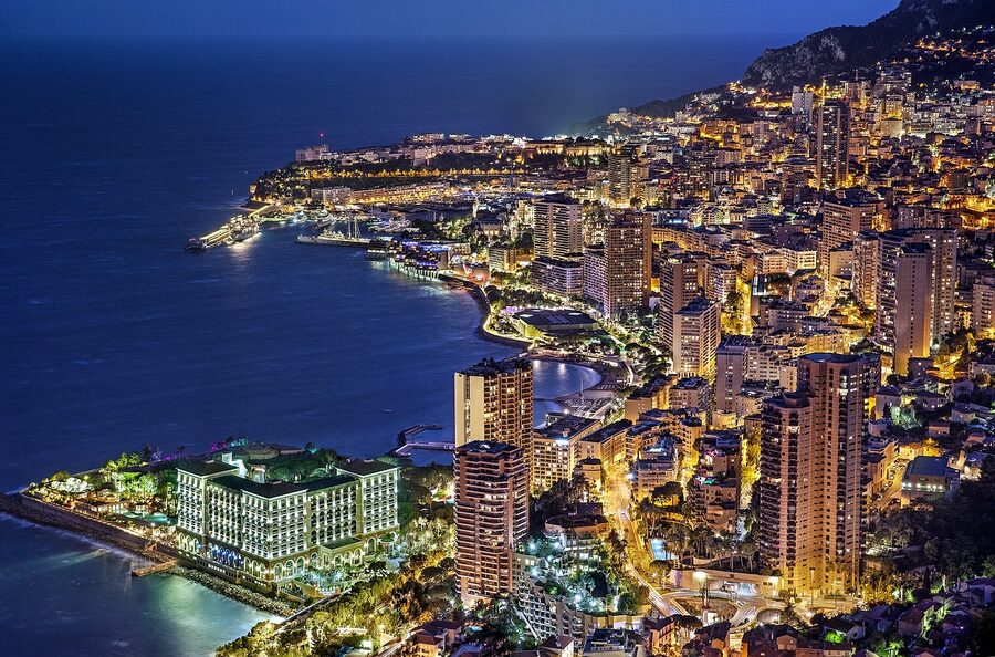 Monaco and Monte Carlo at blue hour with city lights along the coast