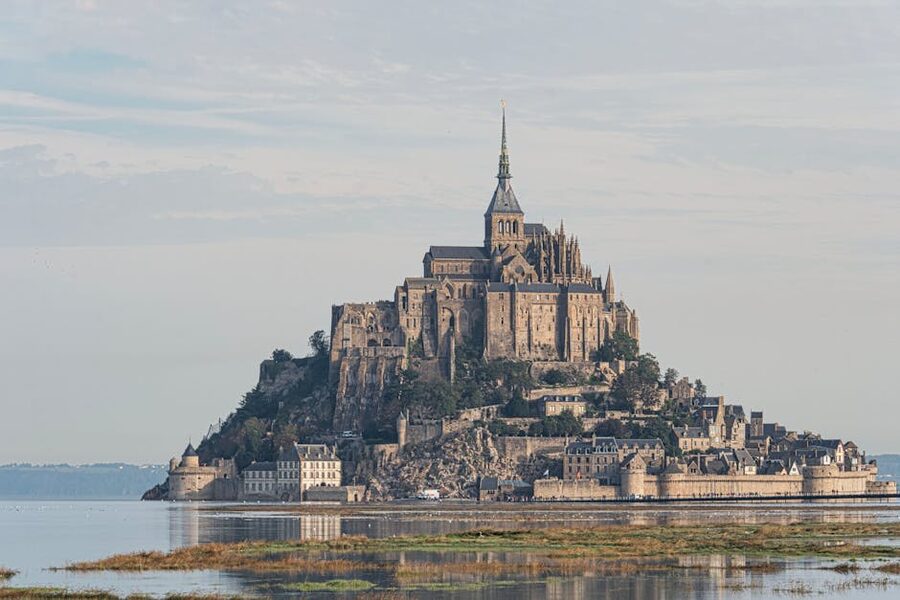 Mont Saint Michel illuminated in the evening with abbey lit up against night sky