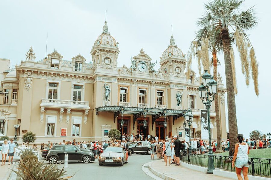 Crowd outside Monte Carlo Casino with luxury cars parked in front
