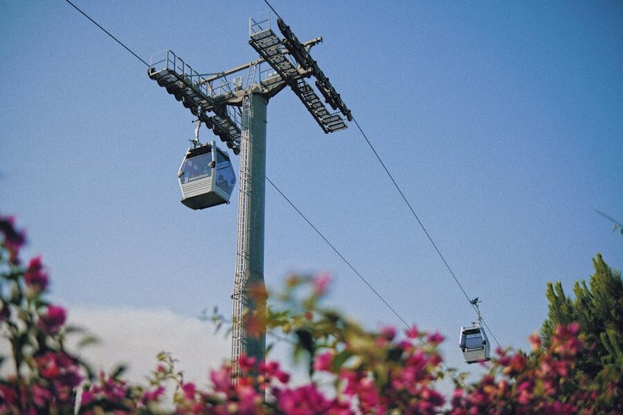 Montjuic Cable Car cabins moving over a hillside garden in Barcelona