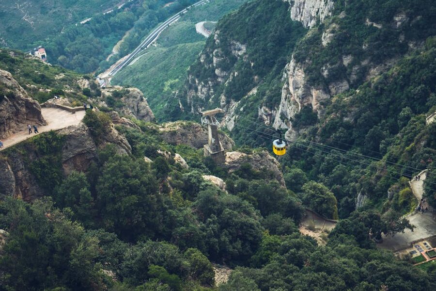 Yellow Aeri de Montserrat cable car suspended over green Catalan countryside