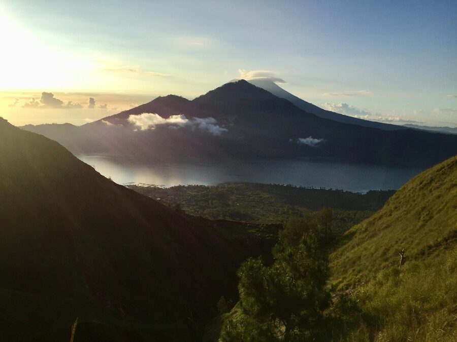 Orange and gold sunrise breaking over the Kintamani region with Mount Batur in view