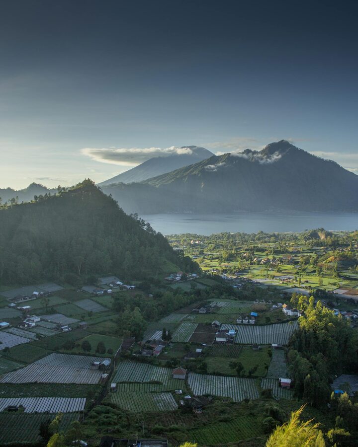 Serene landscape of Mount Batur with lush farmland captured in early morning light