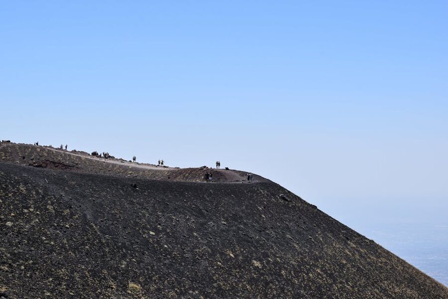 Explorers hiking the rugged terrain of Mount Etna