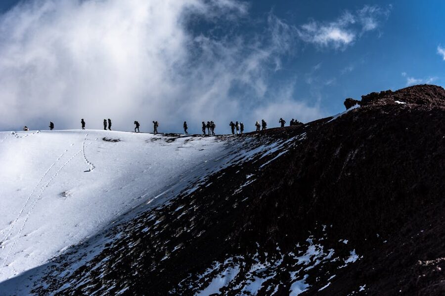 Hikers on snowy slopes of Mount Etna in winter