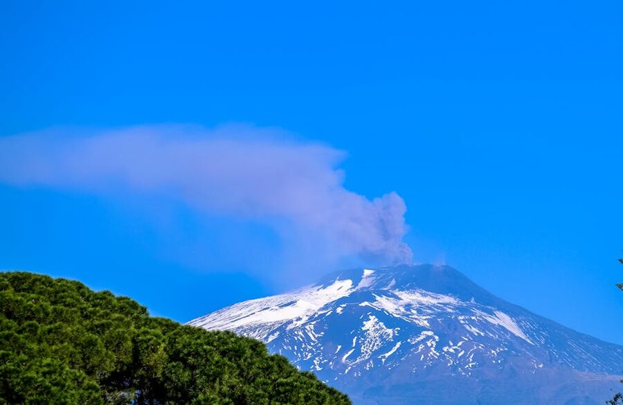 Snow-covered active volcano with smoke rising