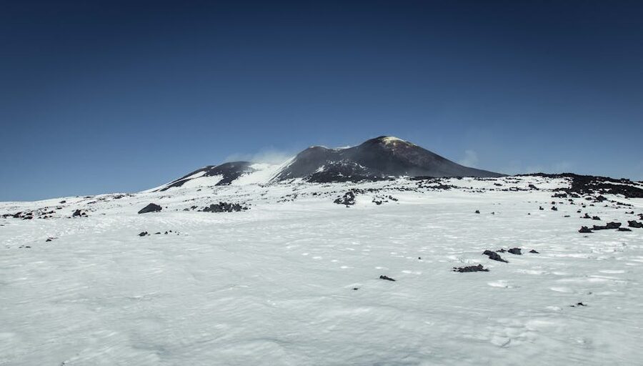 Mount Etna snowy summit under clear sky
