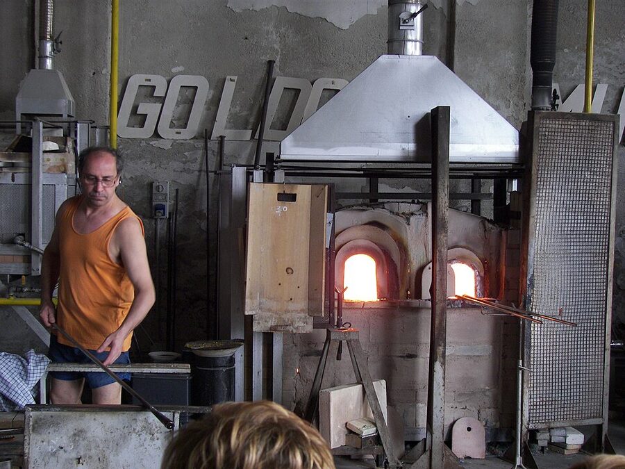 Murano glassworker shaping molten glass at the furnace