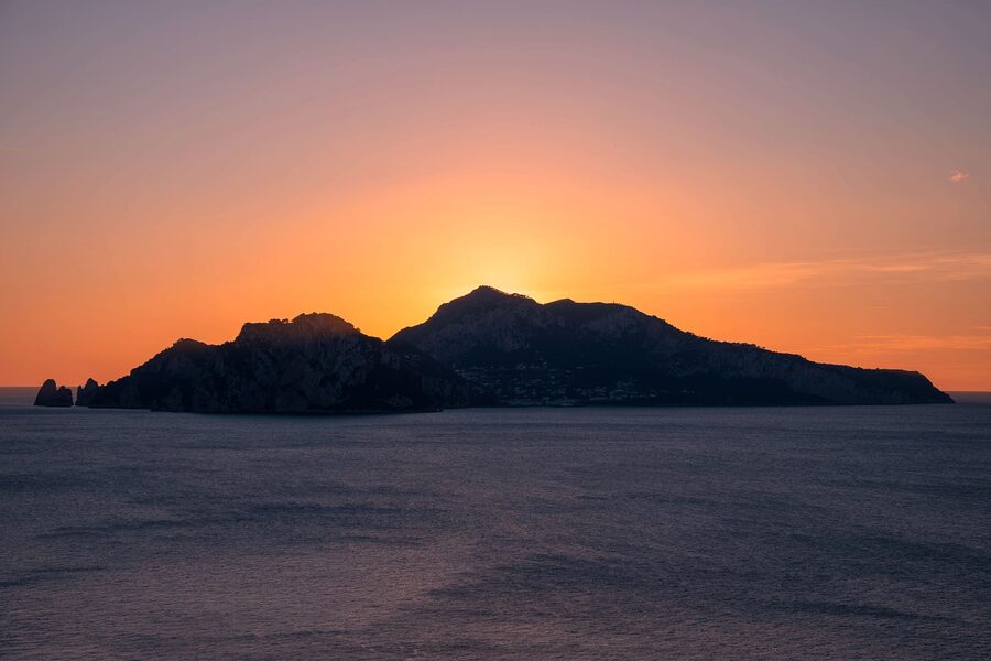 Capri island at sunset with golden light over the sea