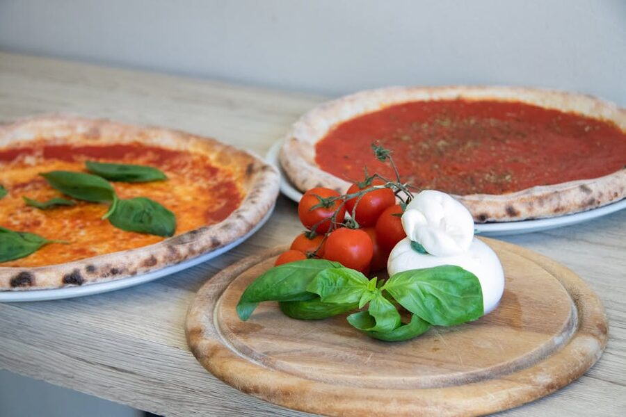 Italian pizzas with basil and cherry tomatoes on display