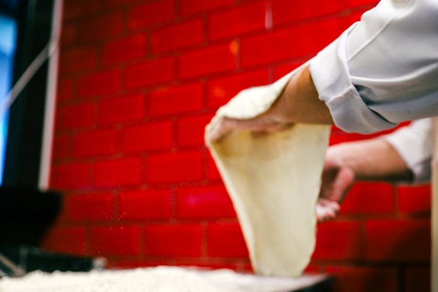 Pizzaiolo stretching pizza dough during a Naples pizza-making class