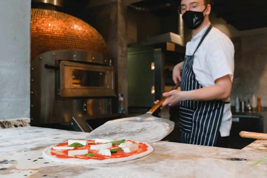 Chef preparing Neapolitan pizza in rustic kitchen