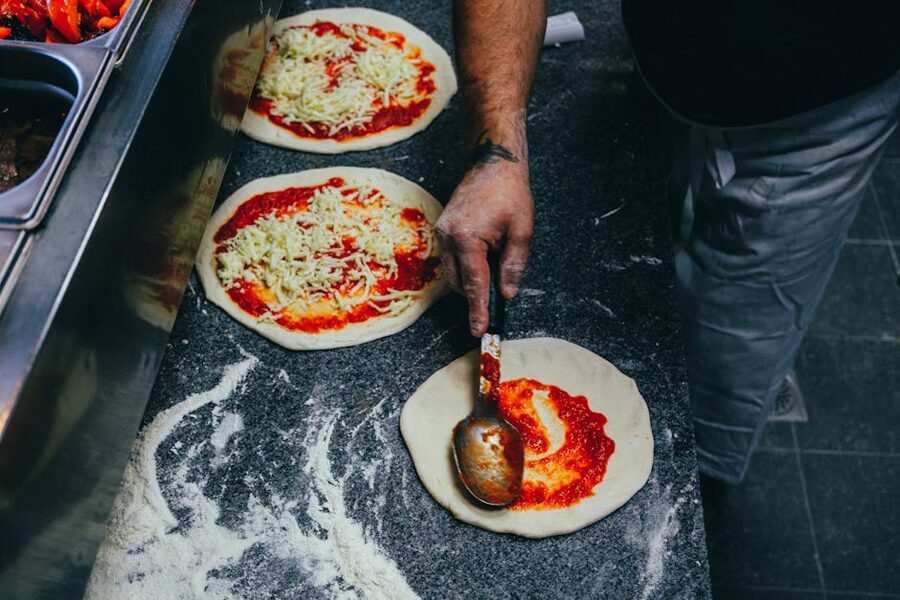 Spreading tomato sauce on pizza dough