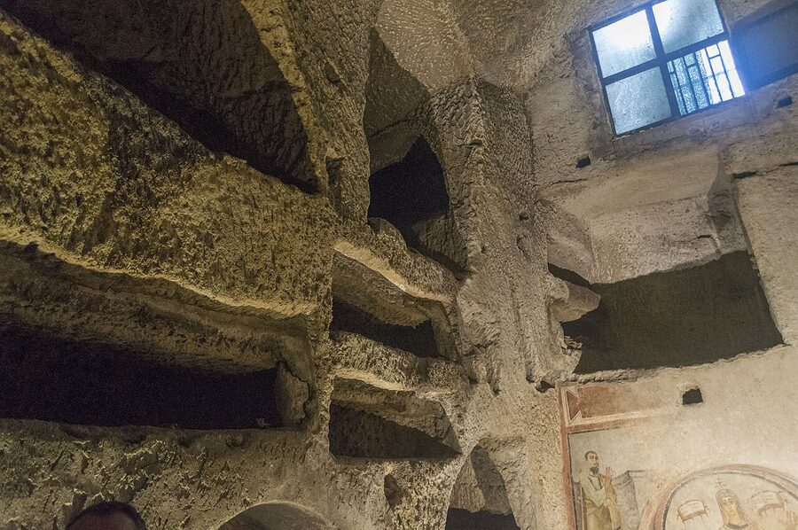 Wall of stacked loculi grave niches in the Catacombs of San Gennaro
