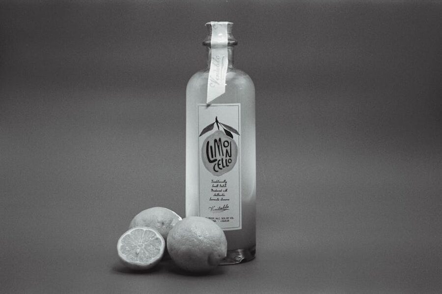 Limoncello bottle with fresh lemons on table