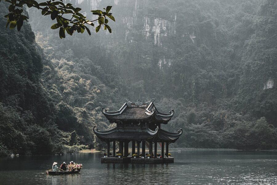 Serene scene of a traditional pagoda on the Tam Coc river surrounded by limestone karsts