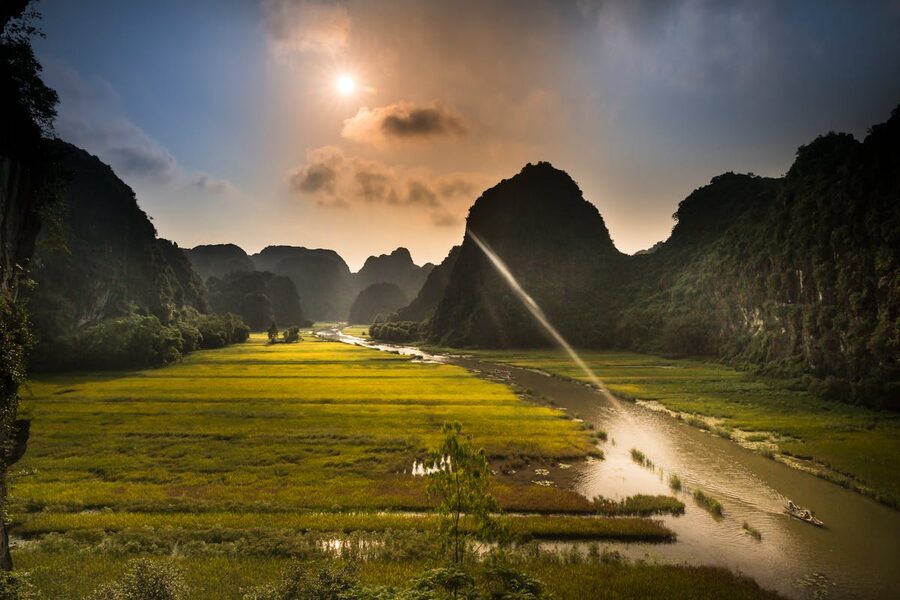 Stunning sunset view over rice fields and river in Ninh Binh Vietnam with dramatic limestone karsts