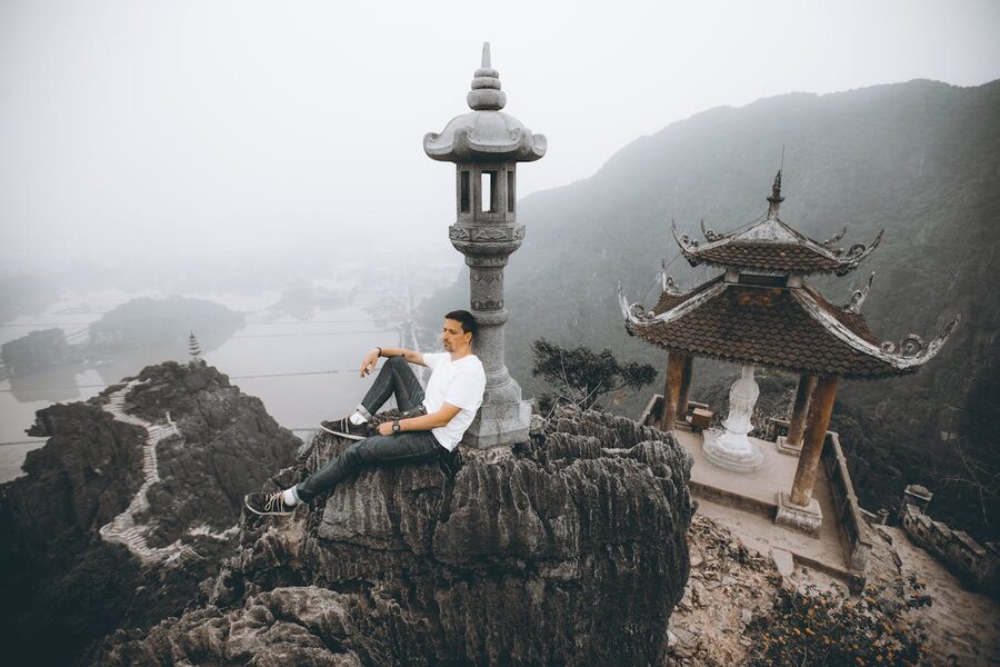A man sitting on a rock at Mua Cave viewpoint overlooking Ninh Binh stunning landscape