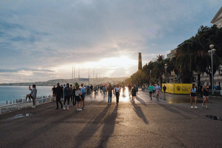 People walking the Promenade des Anglais in Nice at sunset
