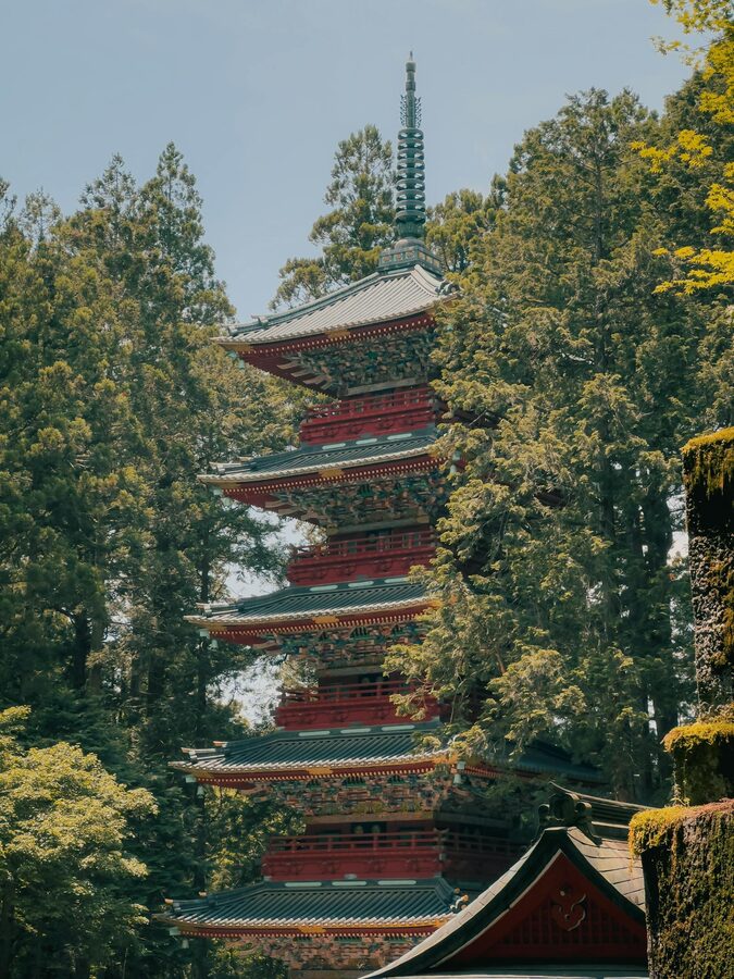Traditional five-story pagoda surrounded by green Nikko forest
