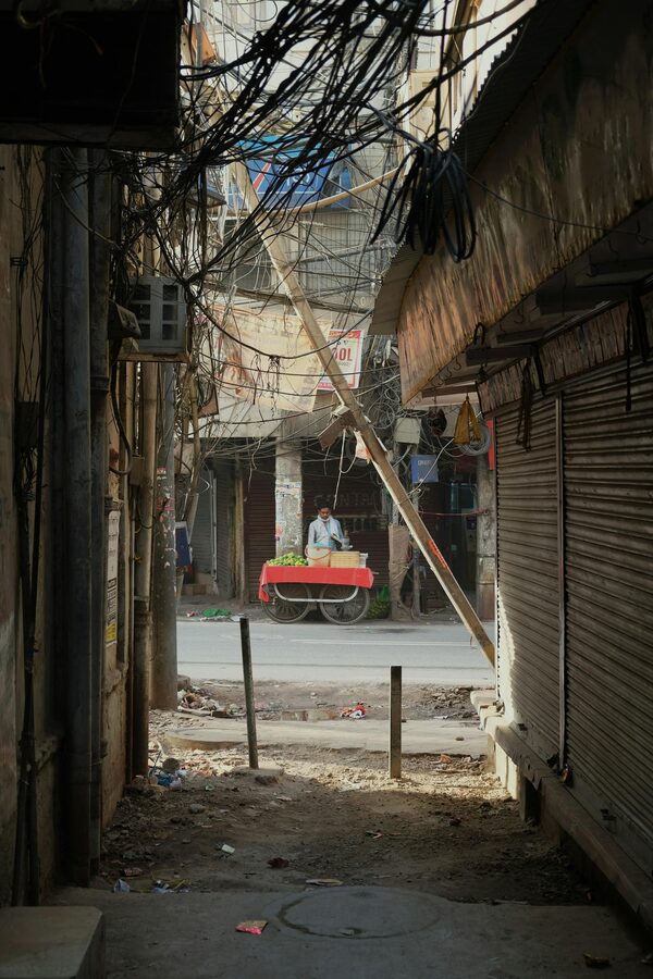 Vendor with a cart in a lively Old Delhi alleyway