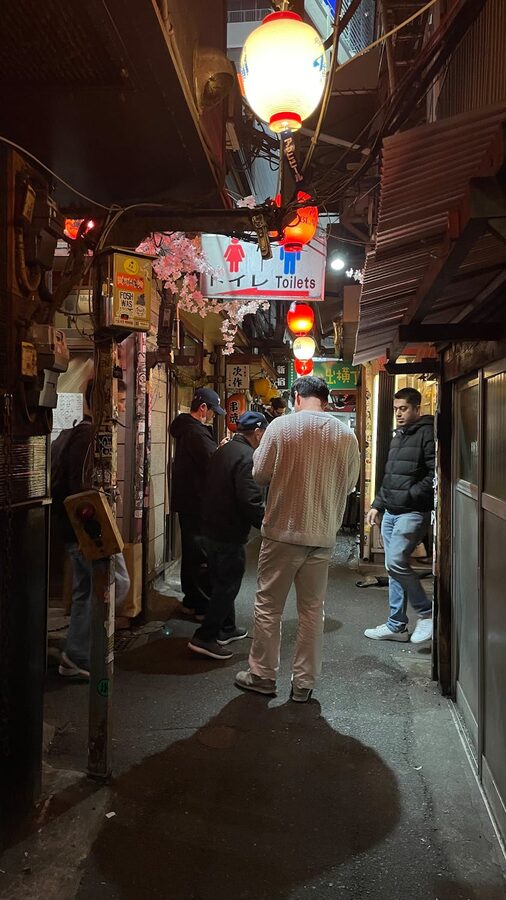 Visitors in the crowded lantern-lit alley of Omoide Yokocho Shinjuku