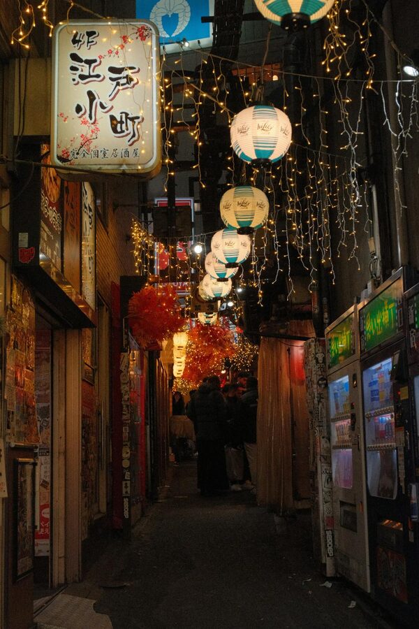 Narrow alley of Omoide Yokocho in Shinjuku lit by lanterns at night