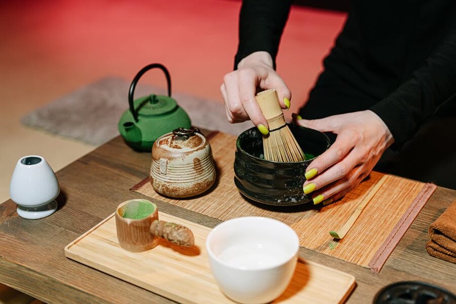 Hands preparing matcha in a traditional Osaka tea ceremony class